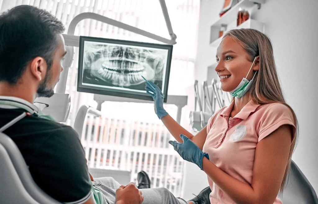 image doctor dentist presenting tooth Depositphotos 518687182 L 1